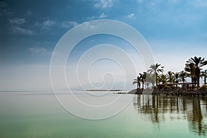 Kinneret, Galilee sea, Israel, Tiberias lake with palms on the seashore calm green water and blue sky. Biblical Place where Jesus