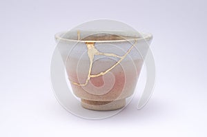 Small beige sake cup repaired with the antique kintsugi real gold technique photo