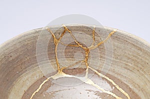 Antique broken bowl repaired with gold kintsugi technique photo