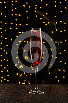 Kir royal cocktail with cherry on wood background