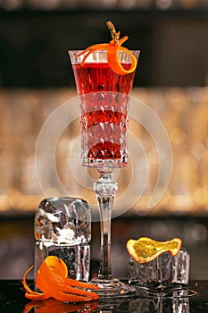 Kir Royal cocktail with orange slice and ice cubes