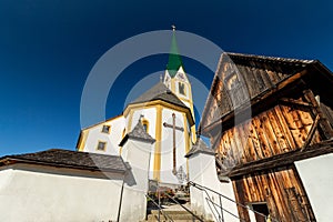 Kirchberg in Tirol, Tirol/Austria - September 18 2018: The white famous church and a wooden structure next to the graveyard shot