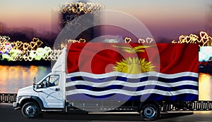 Kiribati flag on the side of a white van against the backdrop of a blurred city and river. Logistics concept