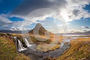 Kirkjufell in Iceland Kirkjufellsfoss waterfall and famous mountain under beautiful blue sky