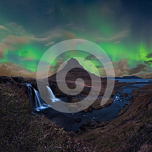 Kirkjufell in Iceland Kirkjufellsfoss waterfall and famous mountain under dancing Aurora