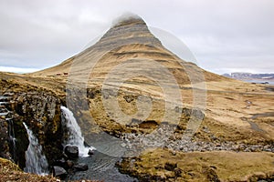 Kirkjufellsfoss waterfall, Kirkjufell mountain, raincloud, hayfield, Iceland