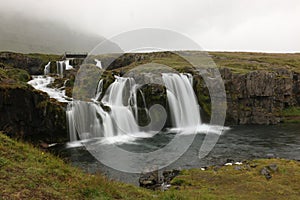 Kirkjufellsfoss waterfall on the rainy day. Iceland.