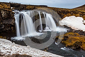 Kirkjufellsfoss waterfalls surrounded by melting snow