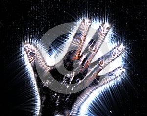 Kirlian aura photography of a glowing human female hand showing different symbols and show of hands