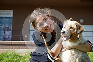 Kirov, Russia - September 13, 2019: Pretty funny girl with nice dog at the grass near entrance to the club for work with dogs