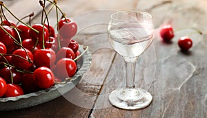 Kirsch or Kirschwasser in a glass and fresh cherry