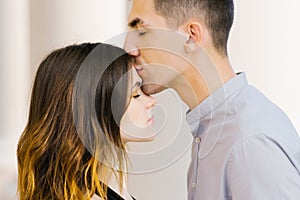 Kiss a beautiful couple in love on the forehead