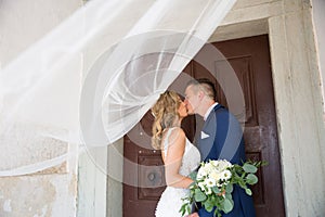 The kiss. Bride and groom kisses tenderly in the shadow of a flying veil. Artistic black and white wedding photo.