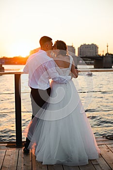 A kiss of the bride and groom at sunset. Wedding article. A happy couple. Love. Photos for printed products.