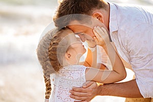 Kiss. dad with daughter walking along sea-shore in windy weather. fun family