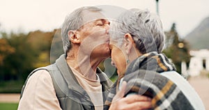 Kiss, forehead and senior couple in a park with love, happy and conversation with romantic bonding. Kissing, old people