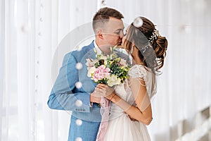 Kiss of the groom and the bride in the room