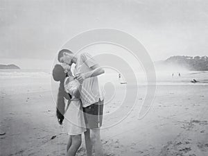 Kiss of a happy young romantic couple in love on the beach.