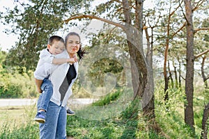 Kiss and hugs of mom and son. Mom and son walk in the summer park. Family holiday and togetherness. Happy mother`s day