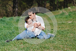 Kiss and hugs of mom and son. Mom and son walk in the summer park. Family holiday and togetherness. Happy mother`s day