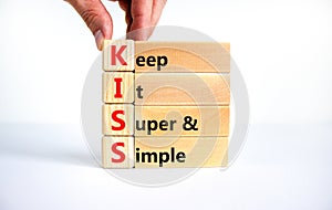 KISS keep it super and simple symbol. Concept words KISS keep it super and simple wooden blocks. Beautiful white table, white