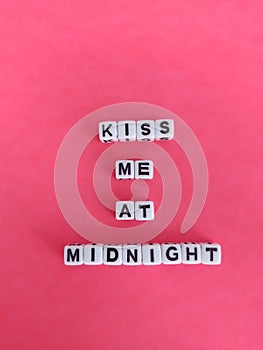 Kiss me at midnight new year poster on a pink background