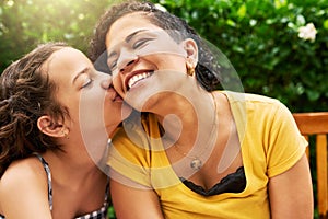 Kisses for mom. Cropped shot of an adorable little girl kissing her mother on the cheek while in the park.