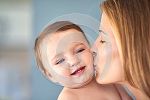 Kisses for mommys cutie. a mother kissing her adorable baby girl on the cheek.