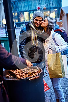Kissing couple buying roasted chestnuts