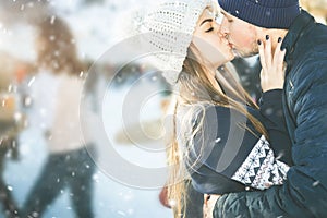 Kissing couple, girls and boy ice skating outdoor at rink