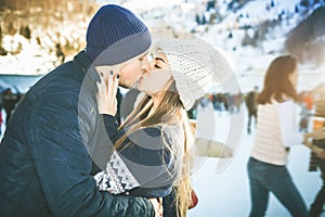 Kissing couple, girls and boy ice skating outdoor at rink