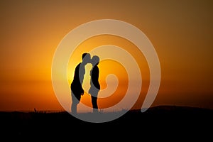 Kissing couple before the lights of sunset