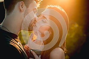 Kissing couple in love. Sexy lovers kiss outdoor at sunset. Sensual Young people. photo