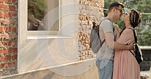 Kissing and cuddling young couple man and woman on the street near the home.