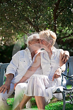 Kissing elderly couple in a garden