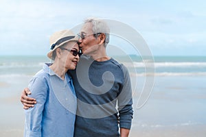 Kissing moment of asian couple senior elder retirement resting at beach honeymoon