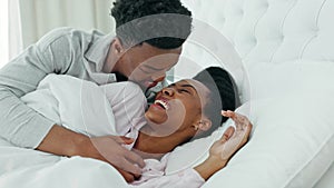 Kissing, morning and couple in bed waking up together in a luxury hotel bedroom or getaway honeymoon retreat. Love, care