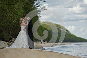 Kissing wedding couple on beach