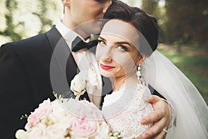 Kissing wedding couple in spring nature close-up portrait