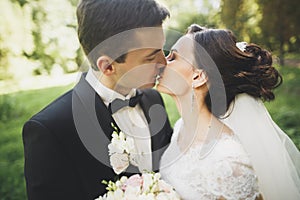 Kissing wedding couple in spring nature close-up portrait