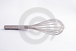 Kitche whisk or egg beater isolated on white background; sensation of fresh and clean kitchen