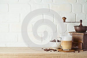 Kitchen background with coffee cup and coffee mill grinder on wooden shelf