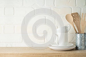 Kitchen background with dishware, utensils, cup and plate on wooden shelf