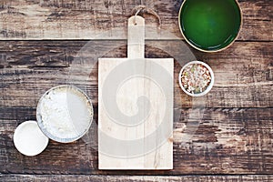 Kitchen background with empty old wooden cutting board and organic ingredients