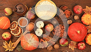 Kitchen background with pumpkin, apples, spices, nuts, flour, eggs, food preparation concept, ingredients for pumpkin and apple