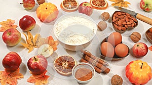 Kitchen background with pumpkin, apples, spices, nuts, flour, eggs, food preparation concept, ingredients for pumpkin and apple