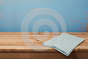 Kitchen background with tablecloth on empty wooden table over painted blue wall