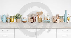 Kitchen bench interior with various herbs, spices, utensils on white