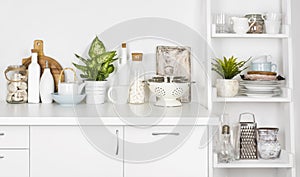 Kitchen bench and shelf with various utensils on white background