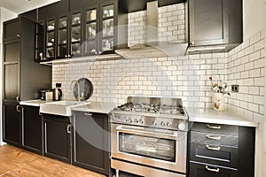 a kitchen with black cabinets and a stainless steel oven